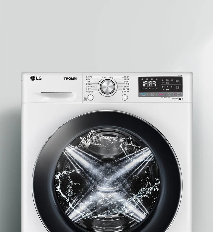 LG 트롬 세탁기가 보입니다. 세탁기 문 안쪽에는 물이 회전하며 세탁이 진행 중인 모습이 보입니다. 세탁기 상단에는 다양한 세탁 모드와 설정을 위한 다이얼과 디지털 디스플레이가 있습니다. 디스플레이에는 시간과 여러 설정 옵션이 표시되어 있습니다. 